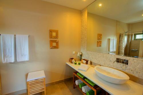 a bathroom with a sink and a large mirror at Ideales Resort in Trapezaki