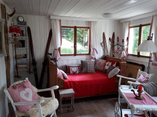 a living room with a red bed and windows at Chalet Chic in Wildhaus