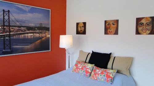 um quarto com uma cama com fotografias na parede em Riverfront studio em Lisboa