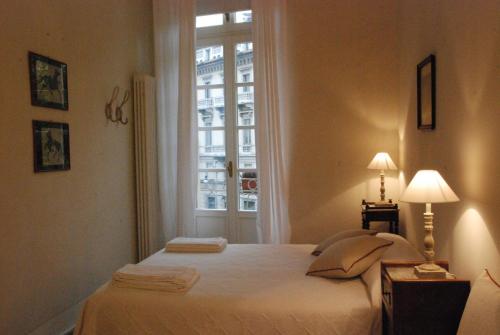 1 dormitorio con 1 cama grande y ventana en Le Porte di Marzo en Turín