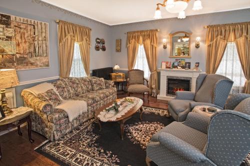 a living room with a couch and chairs and a fireplace at Changing Times Boutique Country Lodging in West Taghkanic