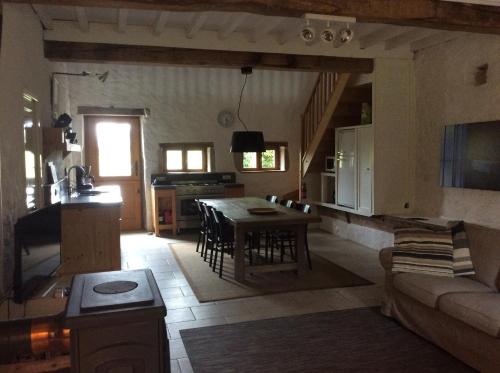 een woonkamer met een tafel en een keuken bij Champ de la Fontaine in Brassy