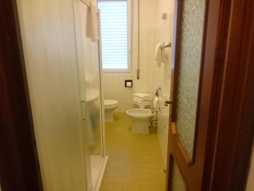 a bathroom with a toilet and a window at Hotel Liliana Andora citr 9006-0004 in Marina di Andora