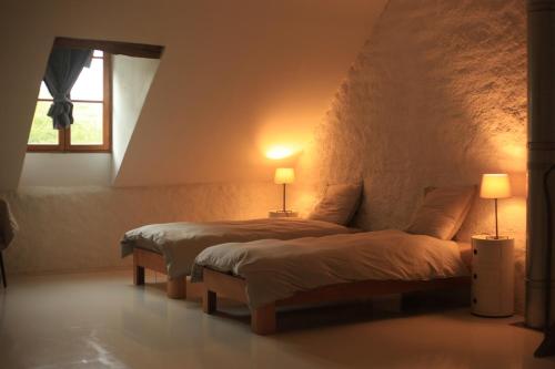 two beds in a room with two lamps and a window at Champ de la Fontaine in Brassy