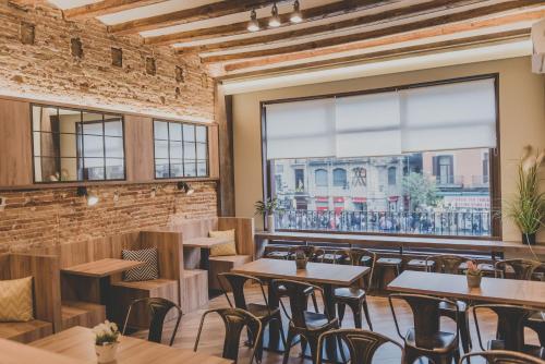 un restaurante con mesas y sillas y una gran ventana en Hostal Marenostrum, en Barcelona