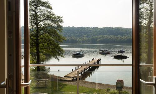 a window view of a dock with boats in the water at Hill Of Oaks in Windermere