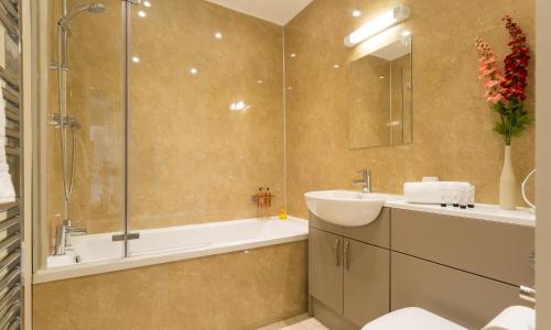 a bathroom with a sink and a shower and a tub at Hill Of Oaks in Windermere