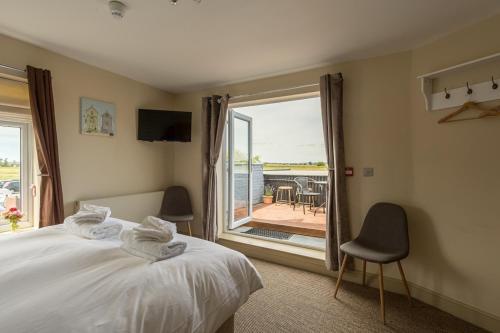 a bedroom with a bed and a view of a patio at The Sail Loft in Southwold