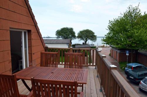 a wooden deck with a wooden table and chairs at Ferienhaus-Am-Strand in Eckernförde