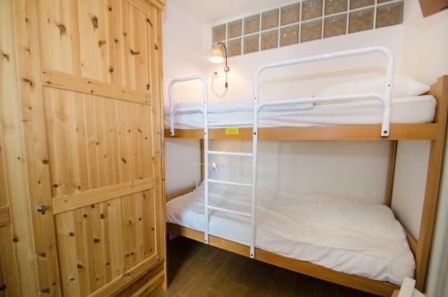 シャモニー・モンブランにあるTetrasの二段ベッド2台とキャビネット付きの二段ベッドルーム1室があります。