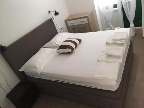 a bed with a striped pillow on top of it at Villa Godinovic in Hvar