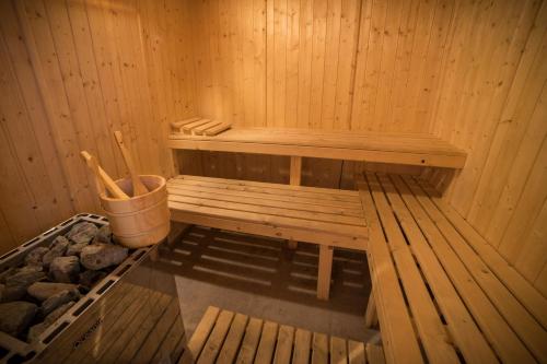 a sauna with a bench and a bucket in it at Chalet les Moineaux Chambres d'Hôtes in Jausiers