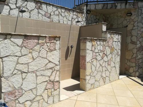 a bathroom with two doors and a stone wall at Kairos B&B in San Giuseppe Jato