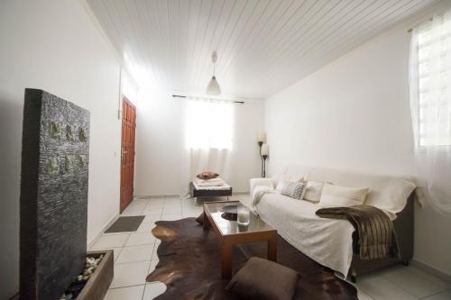 a living room with a couch and a table at Locastudio - Grenadine in Sainte-Anne
