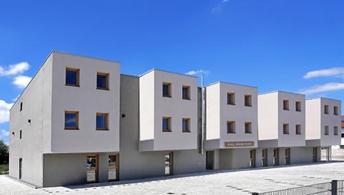 a row of white buildings with a blue sky in the background at easy sleep Apartmenthotel in Landshut