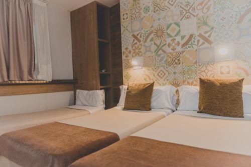a hotel room with two beds and two lamps at Hostal Marenostrum in Barcelona