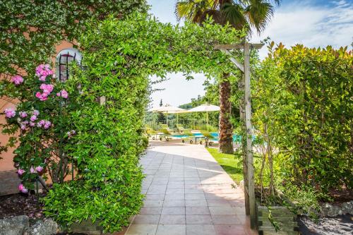 an entrance to a garden with an arch with flowers at Mas Du Roc Bed & Breakfast in Grasse