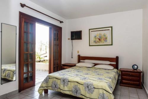 a bedroom with a bed and a sliding glass door at Casa Riviera in Riviera de São Lourenço