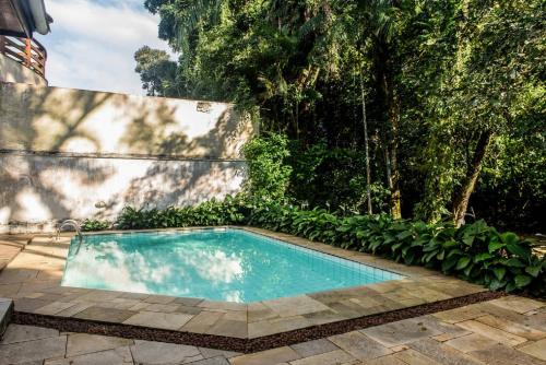 a small swimming pool in a yard with plants at Casa Riviera in Riviera de São Lourenço