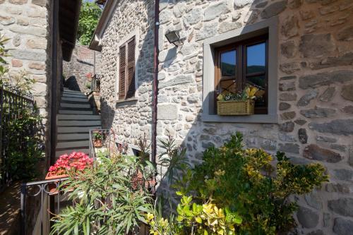 a stone building with a window with a basket of flowers at B&B La Pulce Dorata in Mulazzo