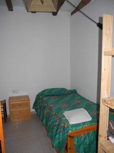 a bedroom with a bed with a green comforter at Apartment Cal Viola in Torroja
