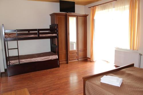 a room with two bunk beds and a television at Panorama Karpat in Polyana