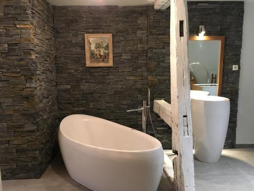 a bathroom with a large tub and a sink at Le P'retzel & Le Sticksy in Riquewihr