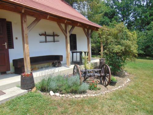 un cenador con un banco en un patio en Rigó Vendégház, en Őriszentpéter