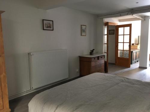 a bedroom with a large bed and a wooden dresser at Le P'retzel & Le Sticksy in Riquewihr