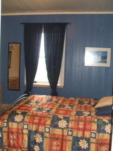 a bedroom with a bed and a window at Gîte Au Coin De La Berge in Perce