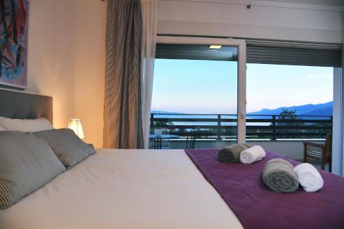 a bedroom with a large bed with towels on it at Apartmani Valis in Matulji