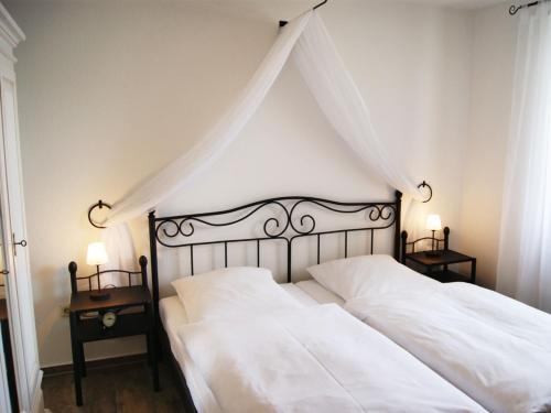 1 dormitorio con 2 camas blancas y 2 mesitas de noche en Appartementhaus Gutenberg, en Binz