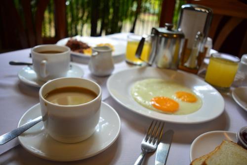 una mesa con dos platos de huevos y café. en Hotel Austria, en León