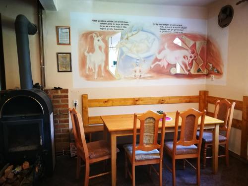 a dining room with a table and a wood stove at Zrcadlová Koza in Turnov