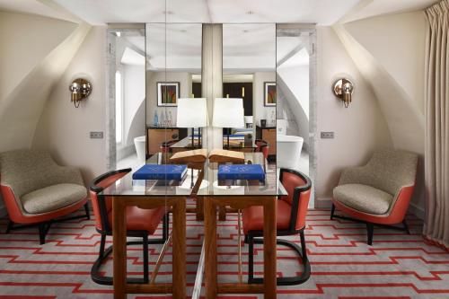 a dining room with a glass table and chairs at Hotel Montalembert in Paris