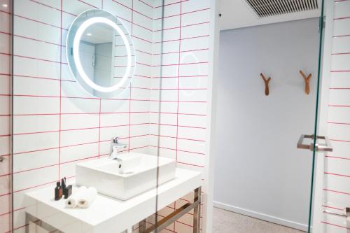 a bathroom with a sink and a mirror at Radisson RED Hotel V&A Waterfront Cape Town in Cape Town
