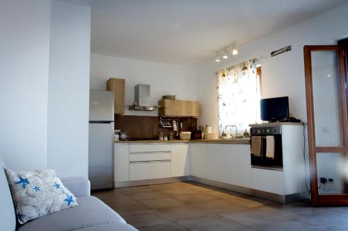 カンポフェリーチェ・ディ・ロッチェッラにあるBarrio Blancoの白い家電製品とソファ付きのキッチンが備わります。