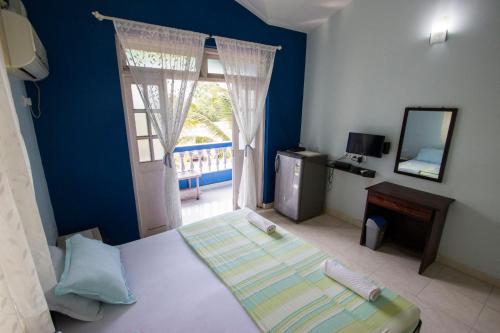 a bedroom with a bed and a window and a mirror at Veeniola Holiday Home in Cavelossim