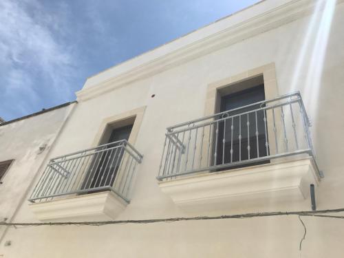 a white building with two balconies on it at Li Caseddi ti lu Cesarinu in Avetrana