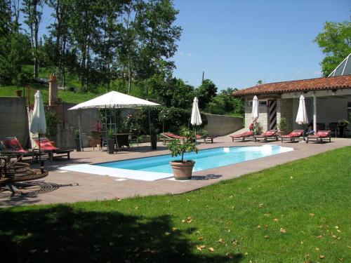 una piscina con sombrillas, mesas y sillas en Belvilla by OYO House with large terrace and pool, en Bastia Mondovì