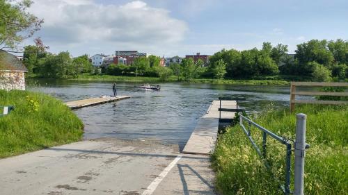a river with a dock and a boat in the water at Motel de l'Outlet in Magog-Orford