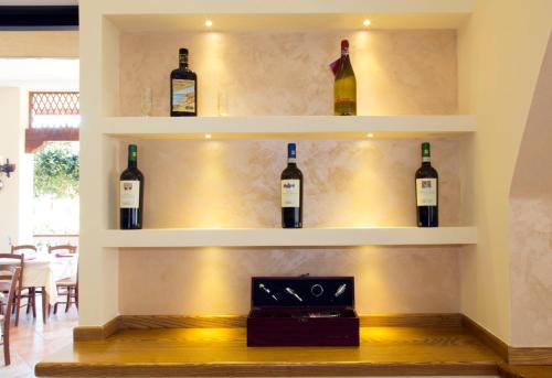 a room with several bottles of wine on the wall at Hotel La Campagnola in Capo Vaticano