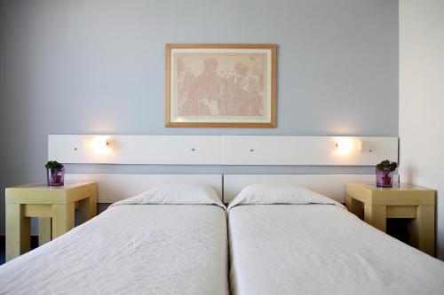two beds in a room with two tables and a picture at Dorian Inn - Sure Hotel Collection by Best Western in Athens