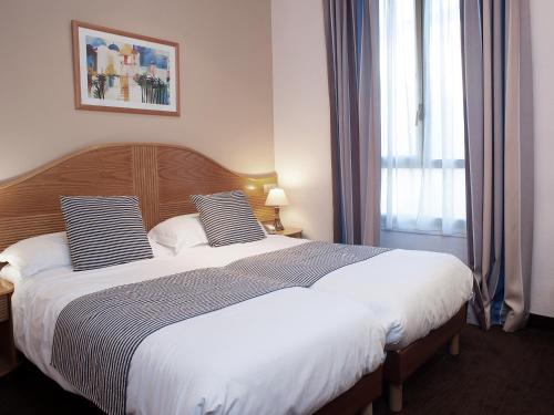 a bedroom with a large bed and a window at Hôtel Esprit d'Azur in Nice