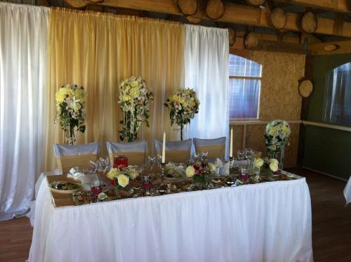 a table with a white table cloth and flowers on it at Europe Guesthouse in Narva