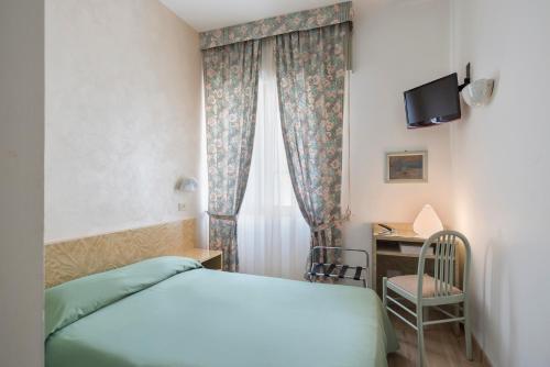 1 dormitorio con 1 cama y escritorio con TV en Hotel Garibaldi en Mestre