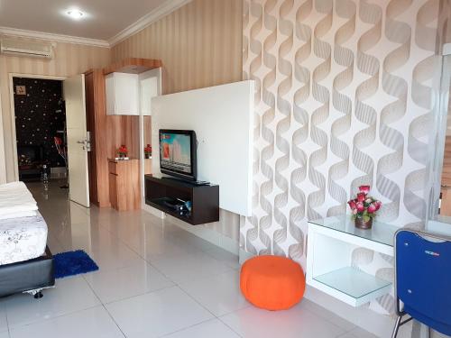 a living room with a tv and a bed at Apartemen MTC 623 in Manado