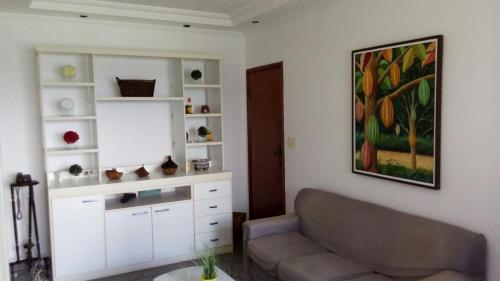 2/4 Farol da Barra في سلفادور: غرفة معيشة مع أريكة ولوحة على الحائط