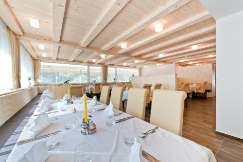una sala da pranzo con tavoli e sedie bianchi di Gasthof Zur Sonne a Cardano
