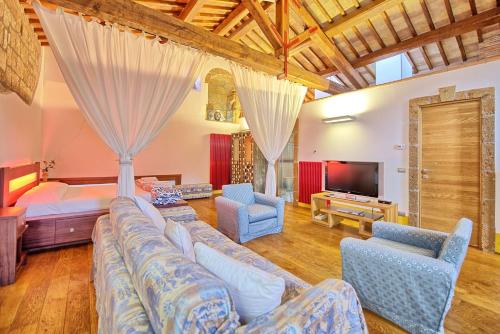 un soggiorno con divano e TV di Voltumna - Le Dimore di Borgo Tessile a Orvieto